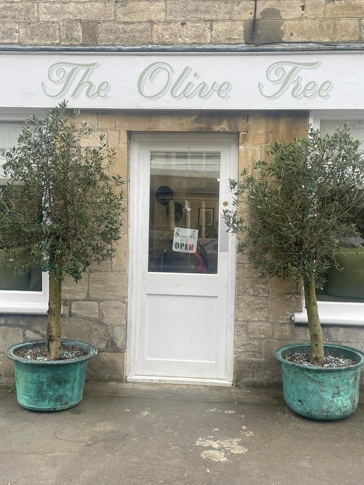 The Olive Tree's stone frontage on Marshfield High Street, flanked by two potted olive trees